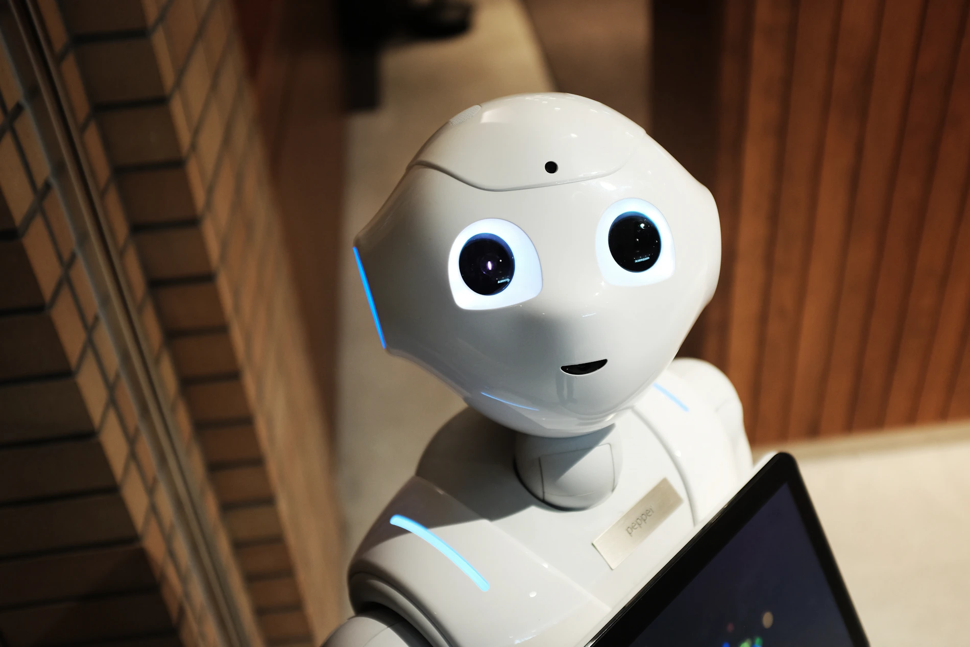 Bijeli industrijski robot pred svijetlom pozadinom u proizvodnom okruženju
